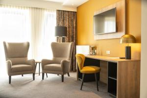 Habitación de hotel con escritorio y 2 sillas en Stadthotel Dinklage, Self-Check In, Restaurant am Hotel, en Dinklage