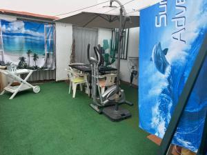 a room with a gym with a table and an umbrella at Beautiful 3-Bed House in Tavira In the city center in Tavira