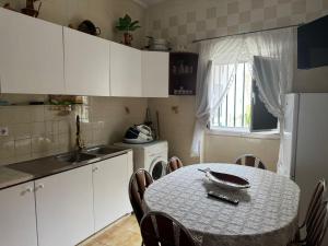 a kitchen with a table with chairs and a sink and a refrigerator at Beautiful 3-Bed House in Tavira In the city center in Tavira