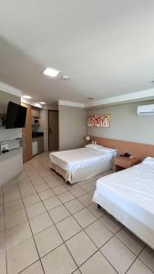 pokój hotelowy z dwoma łóżkami i telewizorem w obiekcie Flat Beira Mar em Recife w mieście Recife