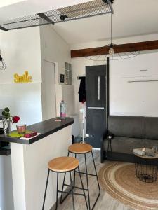 a kitchen with a counter and two stools in a room at Cottage, private terrace in La Rochelle in La Rochelle +1 photo