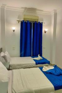 two beds in a room with a blue curtain at Lucky palace Dahab in Dahab