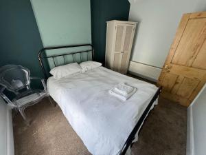 a small bedroom with a bed and a chair at 18 The Wharfage in Telford