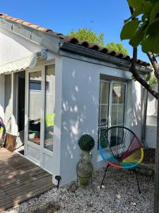 a house with a colorful chair next to a deck at Cottage, private terrace in La Rochelle in La Rochelle