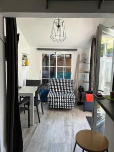 a living room with a table and a chair at Cottage, private terrace in La Rochelle in La Rochelle