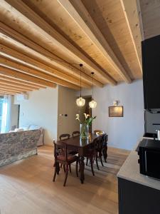 a dining room with a wooden ceiling and a table and chairs at La Maison du Lac Iseo 2 in Predore
