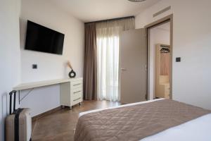 una camera da letto con un letto e una TV a parete di NATURE VIEW a Sárti Altre 26 foto