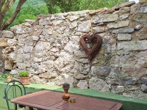 a stone wall with a table and a heart on it at Apartma Under The Drunk Railroad in Kozljak