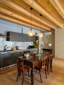 a dining room with a wooden table and a kitchen at La Maison du Lac Iseo 2 in Predore