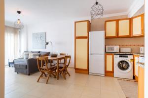 ポルティマンにあるBeGuest Salty Breeze in Portimãoのテーブルと冷蔵庫のあるキッチンとリビングルーム