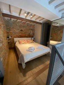 a bedroom with a bed in a brick wall at La stanza dei citti-Lapo in Arezzo