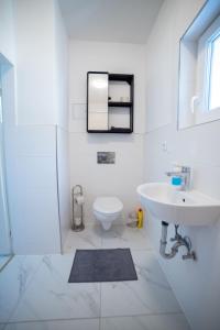a white bathroom with a sink and a toilet at Nord-Apartment 6 I 1 Zimmer mit WLAN & Walk-In Regendusche in Bremerhaven
