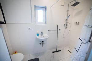 a white bathroom with a shower and a sink at Nord-Apartment 6 I 1 Zimmer mit WLAN & Walk-In Regendusche in Bremerhaven +14 photos