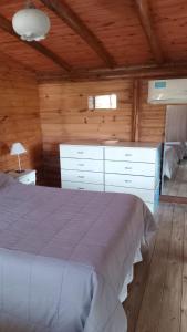 a bedroom with a bed in a wooden room at CABAÑAS BALCON DE PEHUMAYEN in Villa Carlos Paz +9 photos