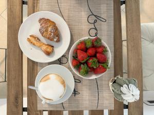 a table with two plates of food and a bowl of strawberries at Halicyae Bed and Breakfast in Salemi
