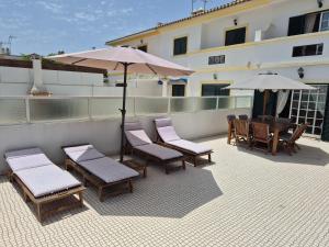 een patio met stoelen, tafels en parasols op een gebouw bij Manta Azul in Manta Rota