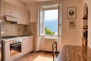 a kitchen with a table and a large window at Villa Pini Balbiani - Appartamento Pini in Lierna