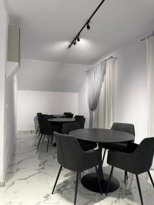Un comedor con mesas y sillas negras. en Hotel Angelo Boutique, en Prăjila