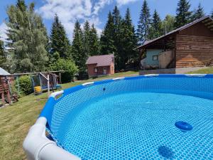 a large blue swimming pool in a yard at Sipi Kulcsosházak in Sântimbru-Băi