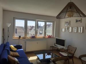 een woonkamer met een blauwe bank en een tv bij Logement Colmar centre avec Parking in Colmar +35 foto's
