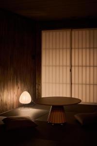 a room with a table and a lamp in front of a window at Alchemy 0 in Osaka
