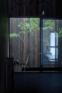 a window in a bathroom with a tree outside of it at Alchemy 0 in Osaka