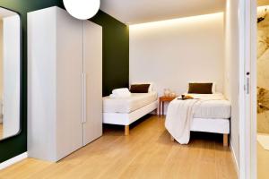 Un dormitorio con dos camas y una pared verde. en SariStays Valencia Modern & O, en Valencia