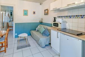 Una cocina y sala de estar con sofá y microondas. en Nid Douillet Entre Plage Et Port, en Le Pouliguen
