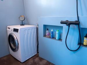 a washing machine in a room with a blue wall at Cosy loft apartment w sauna & Pyhätunturi view in Pyhätunturi