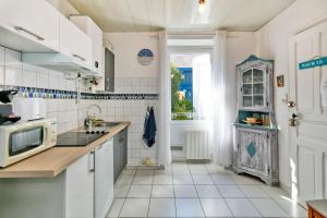 Una cocina blanca con fregadero y microondas. en Nid Douillet Entre Plage Et Port, en Le Pouliguen 16 fotos más