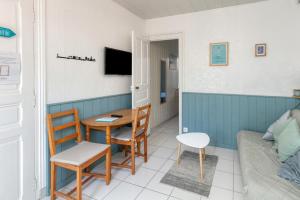Una pequeña sala de estar con una mesa y un sofá. en Nid Douillet Entre Plage Et Port, en Le Pouliguen