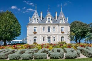 Un edificio antiguo con un jardín delante. en Nid Douillet Entre Plage Et Port, en Le Pouliguen