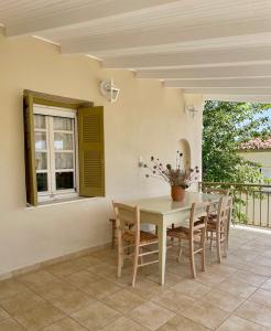 a table and chairs on a patio with a window at GAEA Rooted within in Pylos