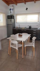 ein weißer Tisch und zwei Stühle in einer Küche in der Unterkunft La agreste in Villa Yacanto