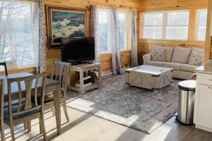 a living room with a couch and a tv at Hunt Acres Grey Cottage in Newcastle