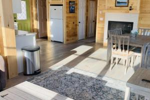 a kitchen and dining room with a table and a refrigerator at Hunt Acres Grey Cottage in Newcastle +2 photos