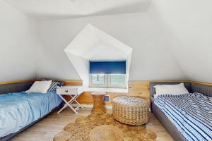 a bedroom with two beds and a desk and a window at Sea Gold in Wells