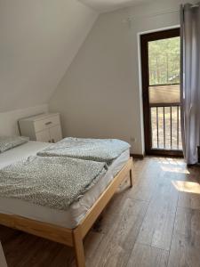 Un dormitorio con una cama y una ventana grande. en Domek Borsk - lotnisko, en Borsk