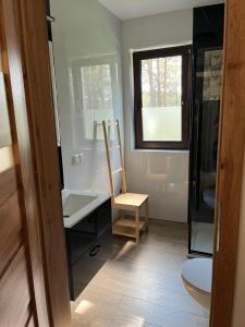 Un baño con una silla y un escritorio y una ventana. en Domek Borsk - lotnisko, en Borsk 19 fotos más