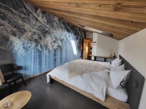 a bedroom with a white bed and a large window at Hôtel-Restaurant Le Cochon Rose in La Sagne