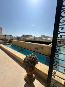 a statue in front of a swimming pool at Riad DAR tya in Sale