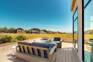 a patio with a couch and chairs on a deck at Cabañita Del Mar in Sea Ranch