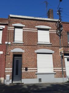 a brick building with white windows and a door at Mi casa es tu casa in Orchies