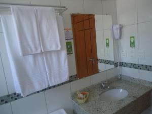 a bathroom with a sink and a mirror at Hotel Dom Baroni in Guarapuava
