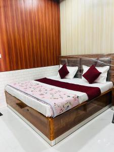 a bed with red and white pillows on it at GAYATRI SHRADDHALU NIWASs in Ayodhya