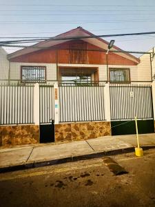 a house with a white fence and a building at Casa Cavancha in Iquique