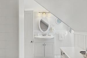a white bathroom with a sink and a mirror at The Wolfeboro House in Wolfeboro +42 photos