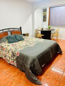 a bedroom with a bed and a table and a screen at Casa Cavancha in Iquique