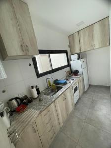 a small kitchen with wooden cabinets and a sink at Apartment del centro in Santa Rosa
