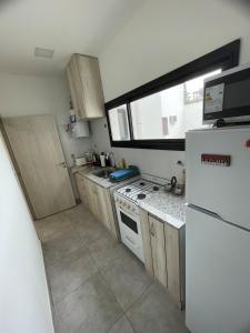 a small kitchen with a refrigerator and a stove at Apartment del centro in Santa Rosa